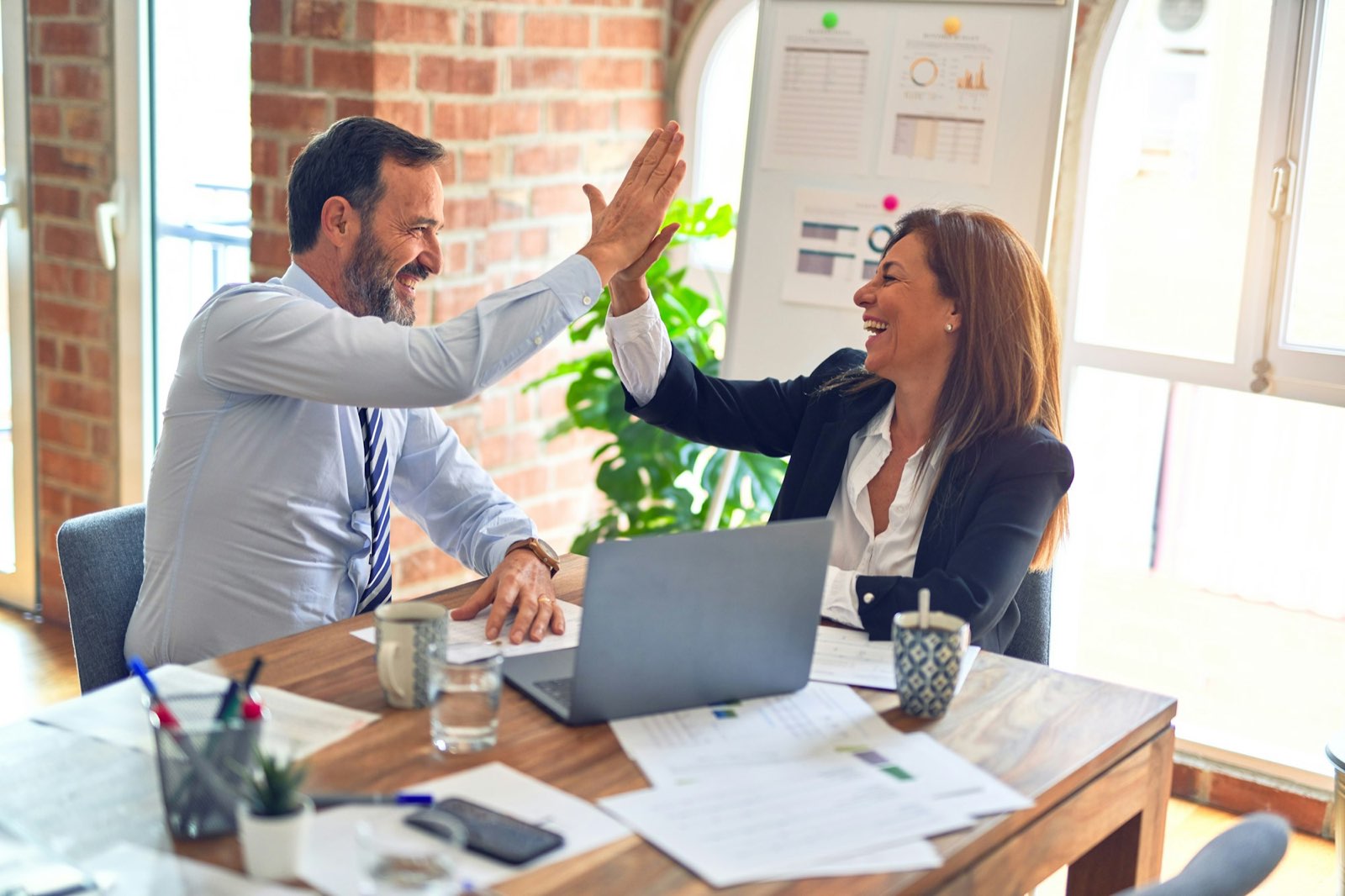 Two loan officers celebrating a closed deal in the office